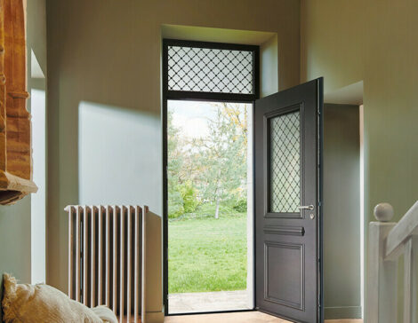 porte entree gris anthracite avec une imposte vitrée avec grille dans un intérieur de maison au style traditionnel