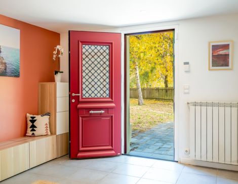 porte d'entrée rouge Athéna de style traditionnel dans une maison moderne avec un mur corail