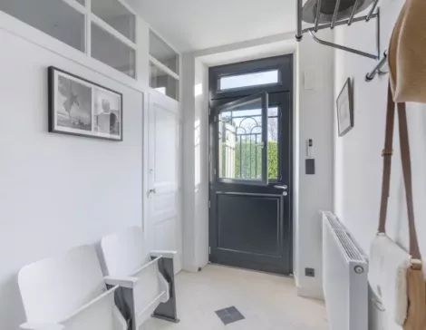 porte d'entrée en bois vitrée avec chassis ouvrant dans un intérieur de maison lumineux