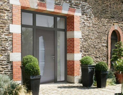 porte d'entrée avec imposte au style moderne associée à deux fixes vitrés sur une maison en pierre