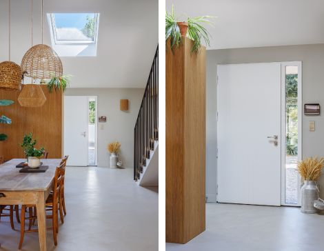 Entrée de maison lumineuse avec une porte d'entrée moderne et blanche, un sol en béton ciré et des murs clairs