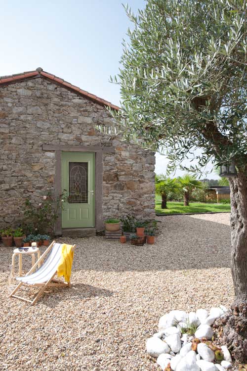 une porte d'entrée traditionnelle en acier sur une maison de style campagne avec un mur de pierre