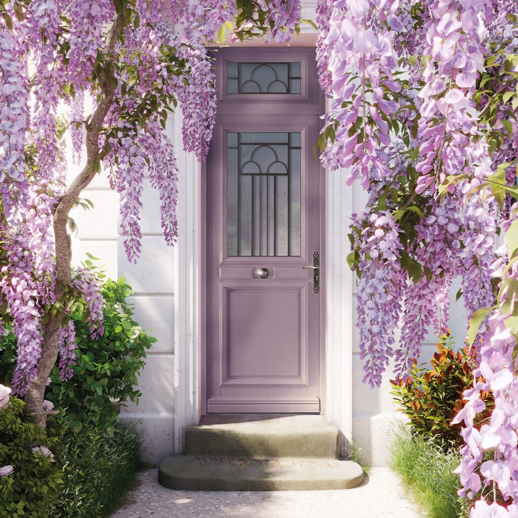 une porte d'entrée avec une imposte de couleur violette entourée de glycines violettes