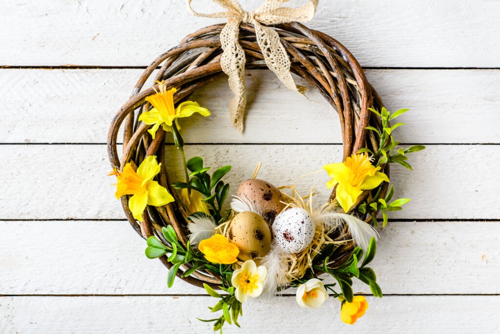 une couronne en bois avec des jonquilles et des œufs pour pâques