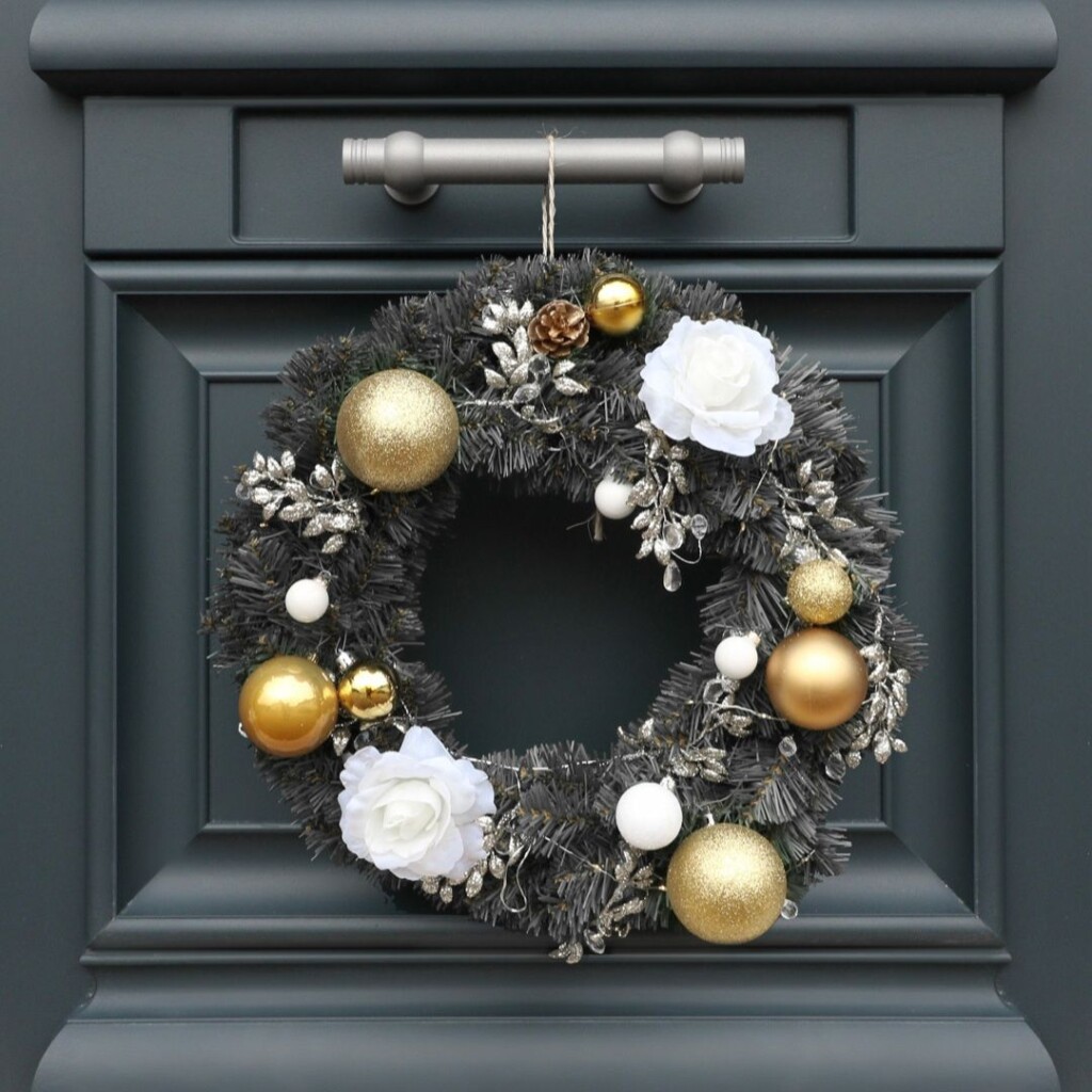 couronne de noel sur une porte d'entrée bel'm avec du sapin artificiel et des boules de noel