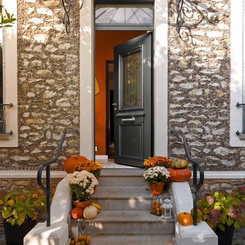 extérieur de maison avec un perron décoré avec des fleurs et courges disposées sur les marches