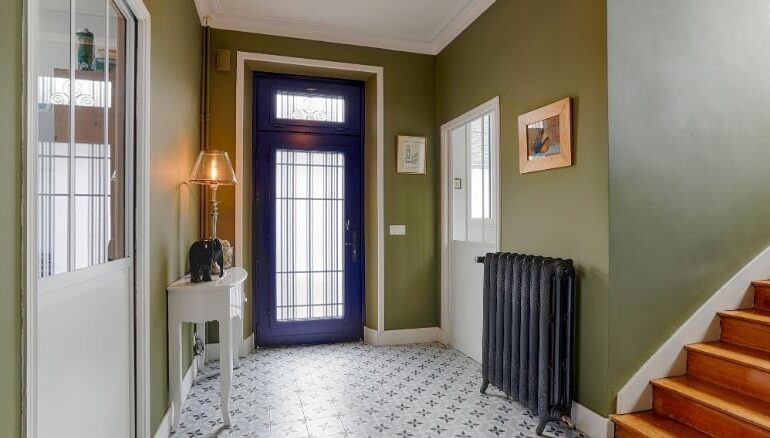 vue intérieur d'une maison avec une porte d'entrée sur mesure en bois ouverte