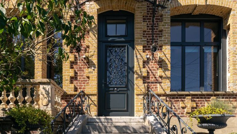 porte d'entrée en bois sur mesure avec imposte au style traditionnel sur une maison en brique