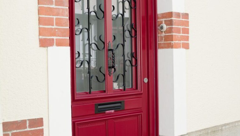 porte d'entrée en bois vitrée rouge avec un vitrage, une grille et une boite aux lettres