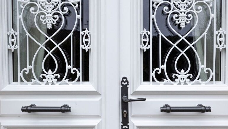zoom sur une porte d'entrée en bois avec une grille sur mesure