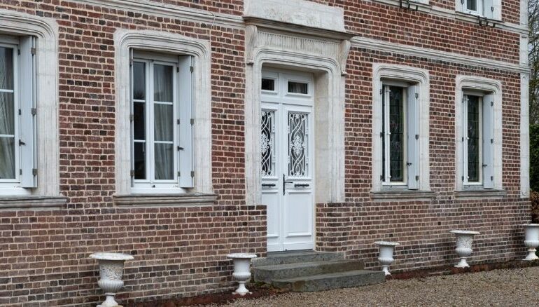 porte d'entrée en bois sur mesure 2 vantaux sur une maison en brique