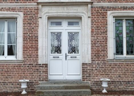 porte d'entrée en bois sur mesure sur une maison en brique